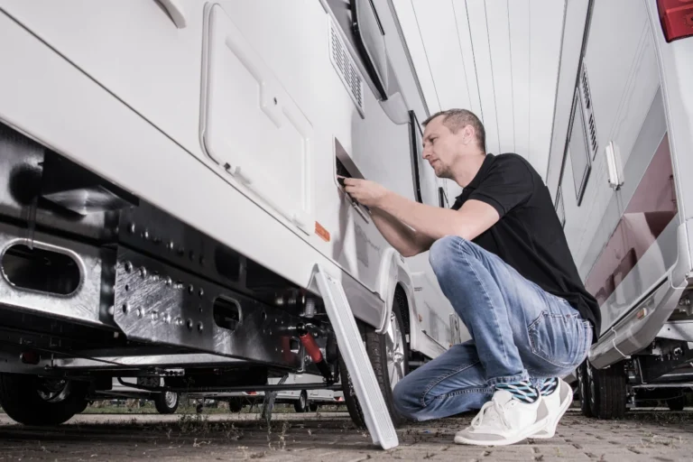 a man servicing the exterior of an RV recreational vehicle